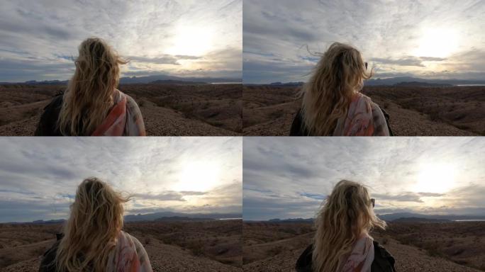 成熟的女人从沙漠山脊峰望去日出