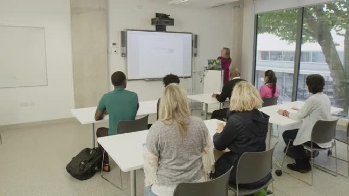 成熟的学生在教室的讲台上听女老师