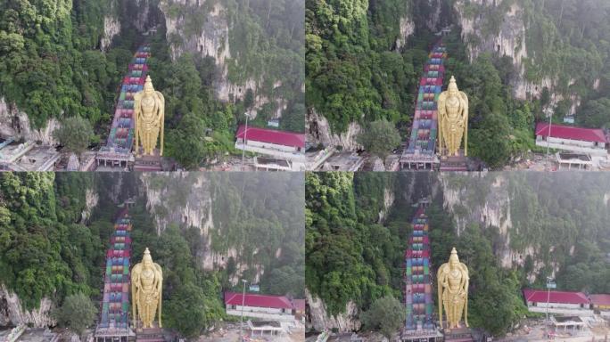 航拍无人机旋转拍摄的拔都石窟，在白天的马来西亚吉隆坡，印度教领主穆卢干雕像居住在色彩缤纷的台阶上。