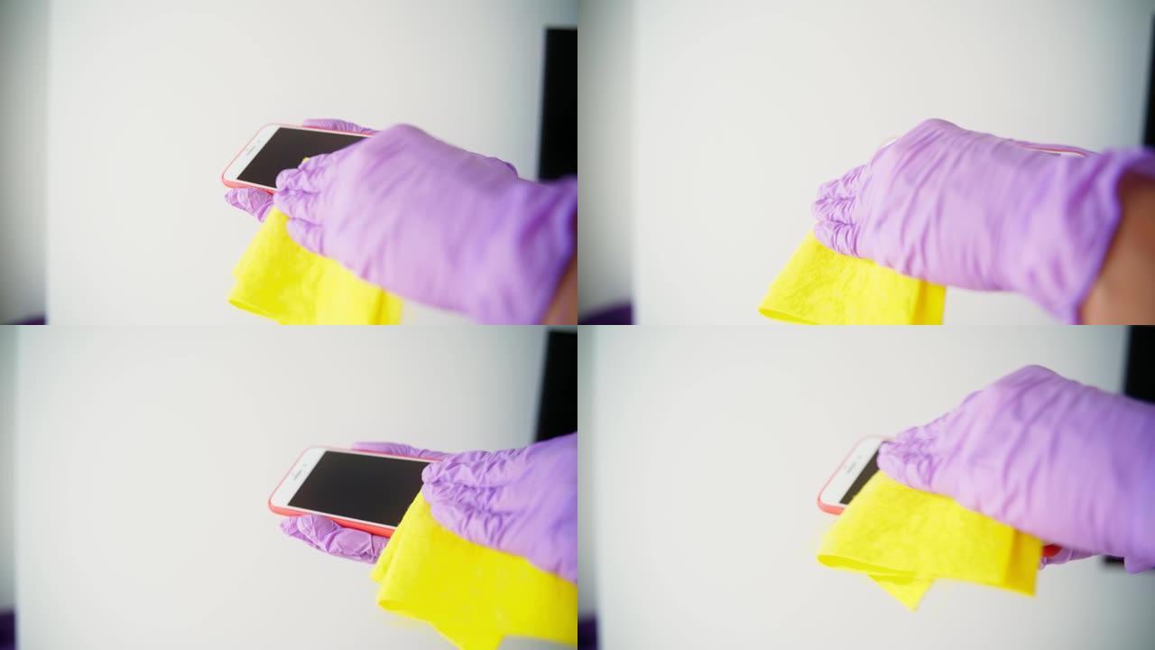 用乳胶手套清洁智能手机屏幕的手的特写镜头