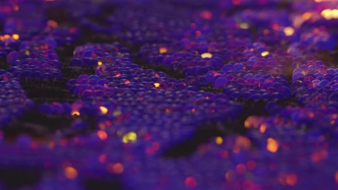 织物上紫色和金色亮片的宏观视图，用手抚摸时明亮地反射光线并改变颜色4K