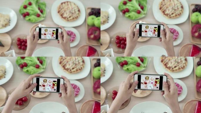 女性使用手机拍摄食物或在社交网络应用程序上拍摄实时视频。午餐的食物看起来很开胃。摄影和拍照以回顾食物