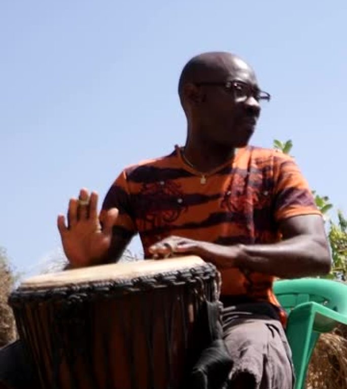 黑人与kenken和djembe一起扮演dunun的宽镜头的垂直视频