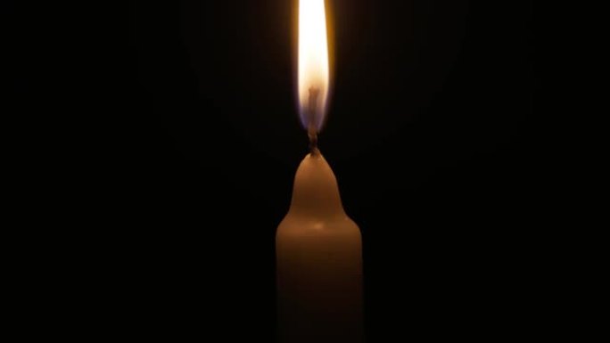 用黑色背景上的火柴手灯蜡烛。黄色火的白色蜡烛。记忆、仪式、庆祝的概念