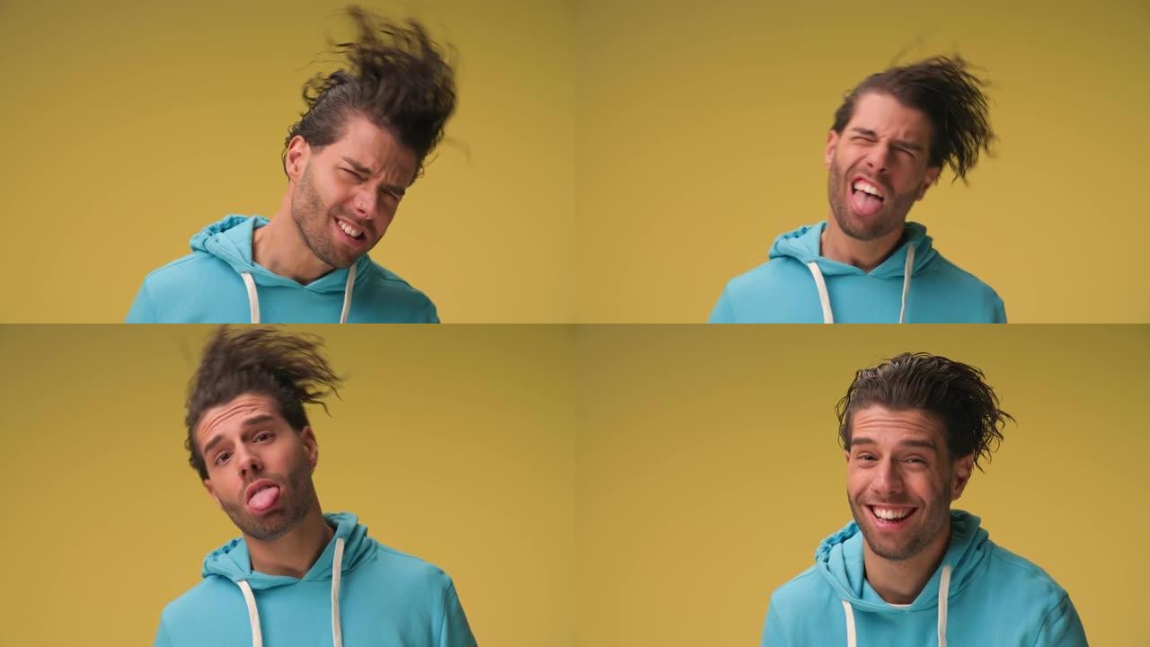 项目视频有趣的帅哥卷发长发动头，跳舞，做傻脸，在黄色背景上笑