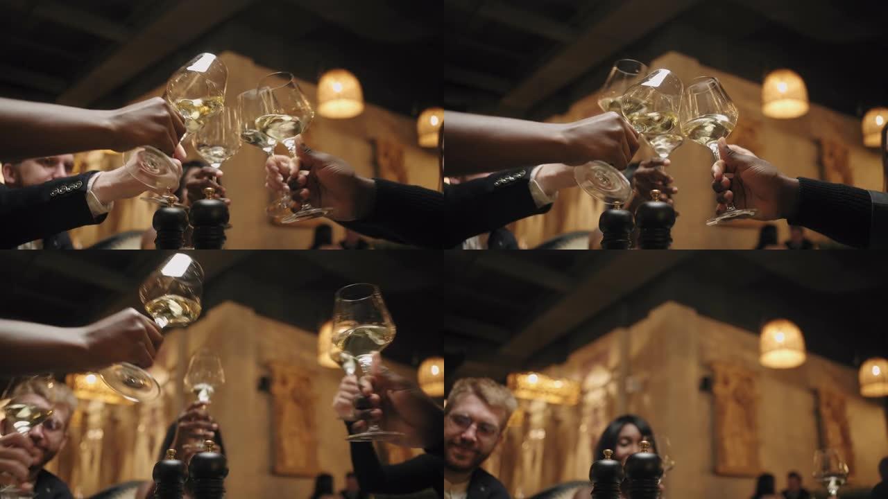 同事在餐厅庆祝大笔交易或新年，用香槟叮当眼镜，特写镜头