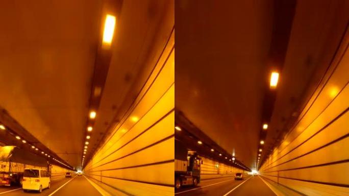 开车穿过高速公路隧道。高速公路隧道出口。隧道尽头的光
