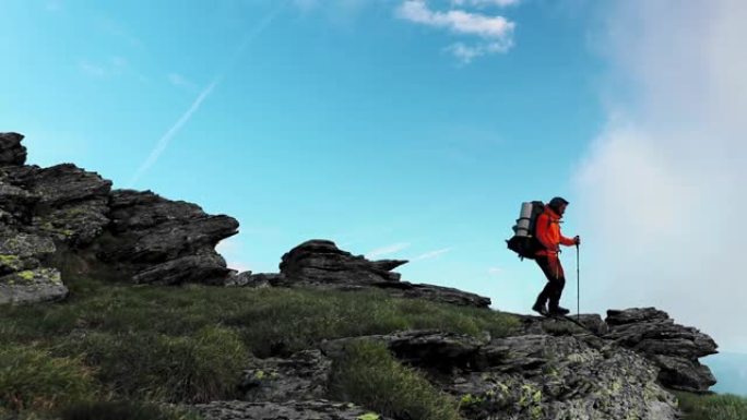 单人男徒步旅行者穿着大背包，在罗马尼亚的法加拉斯山上行走