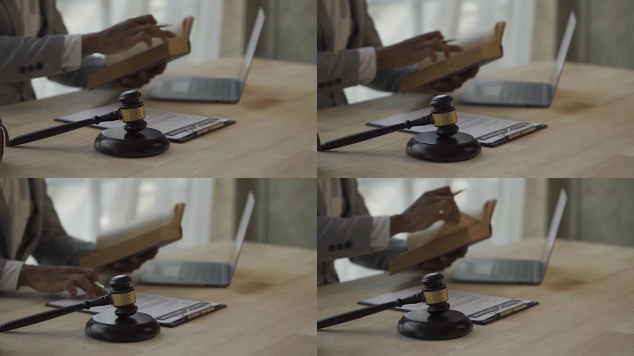 法庭上的男法官在木桌上和在法律和司法办公室工作的男律师在办公室翻法律书的页面大法官雕像锤的选择性焦点