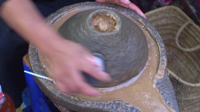 摩洛哥柏柏尔妇女在石制手工磨磨摩洛哥坚果油研磨杏仁