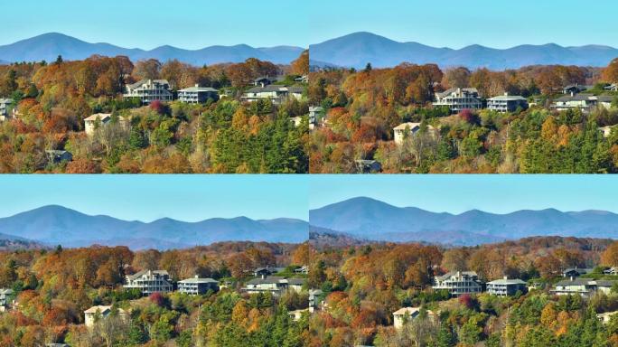 从北卡罗来纳州郊区黄色秋天树木之间的山顶高处的昂贵住宅的上方观看。美国梦homes作为美国郊区房地产