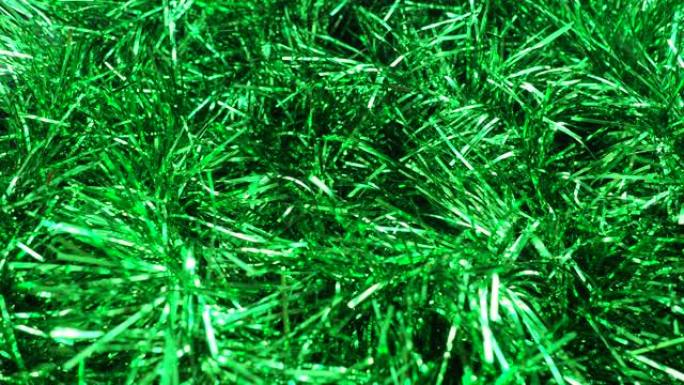 绿色明亮的金属丝在风中或选秀中飘扬。圣诞树、室内或冬季街道的圣诞节和新年装饰。空气呼吸下圣诞树针的运
