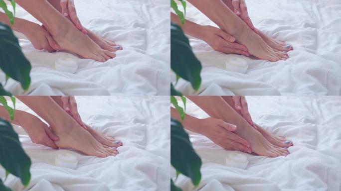 女人的手用奶油润滑脚。护肤概念。自爱