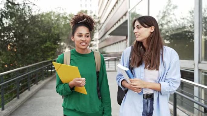 两名大学生女生朋友在大学校园里畅谈散步