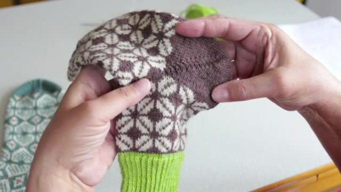 女人用编织针编织柔软的羊毛袜子。