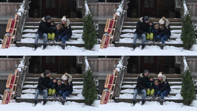 一家人带着两个孩子在下雪的森林里拉着圣诞树