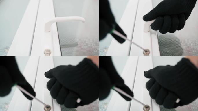 戴着黑色手套的手正试图用万能钥匙撬开白色门上的锁，特写，俯视图。坏人正试图进入房间。非法入境