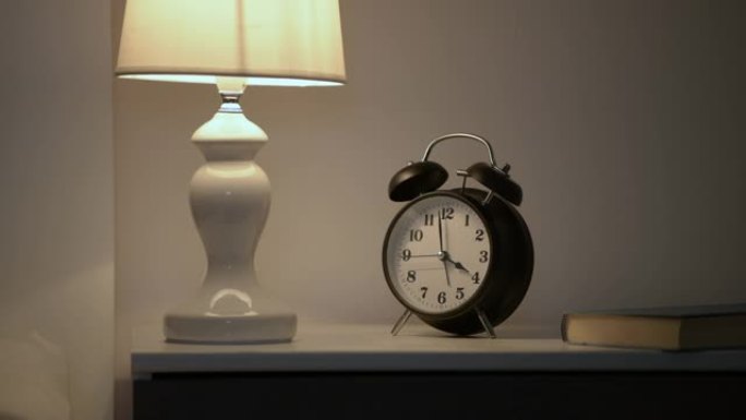 卧室床头灯和早晨4点的时钟为失眠概念