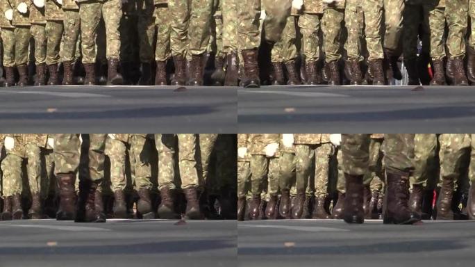 身着迷彩服的士兵们的腿在街道上游行，民众在围栏后面观看
