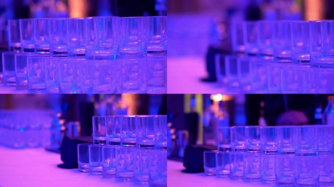 酒吧柜台上的水晶眼镜，迪斯科音乐和彩色照明的夜总会，为客人准备的酒精饮料，如葡萄酒，香槟，威士忌，龙