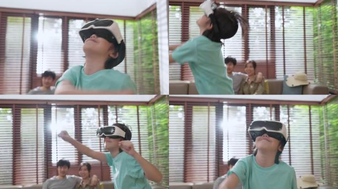 亚洲家庭儿子戴着VR或虚拟现实眼镜，头戴式耳机在检疫时期的电视前的客厅站立和玩视频游戏技术与创新理念