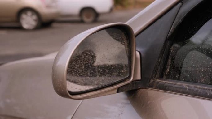 沙尘暴后汽车上肮脏条纹的特写。汽车上的灰尘和污垢