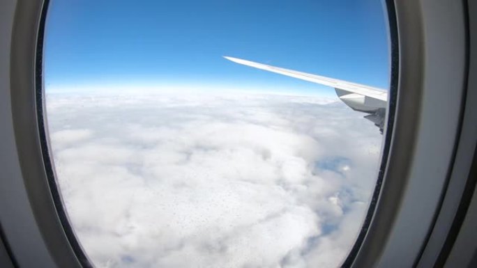 飞机在云层上空飞行，望着蓝天