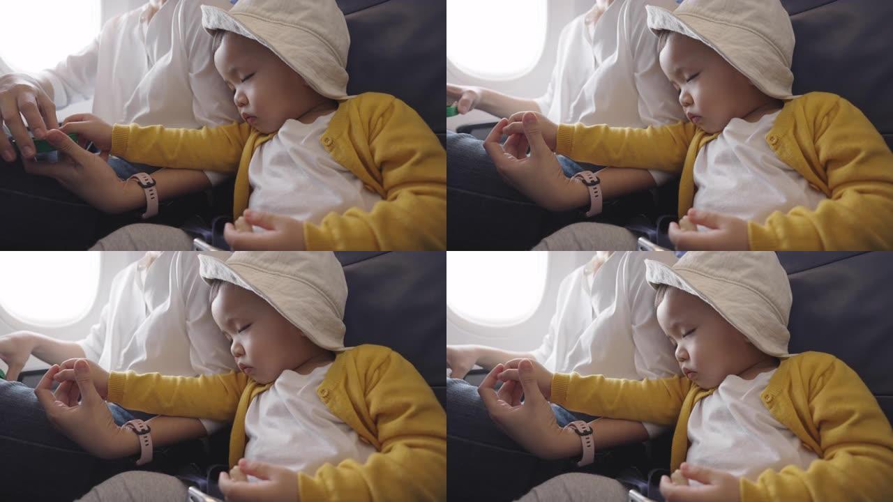 疲惫的亚洲华裔男童在飞行途中睡觉