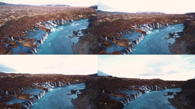具有电影运动的无人机从多个角度在日落光线下展示了美丽的冰岛瀑布Hraunfossar。