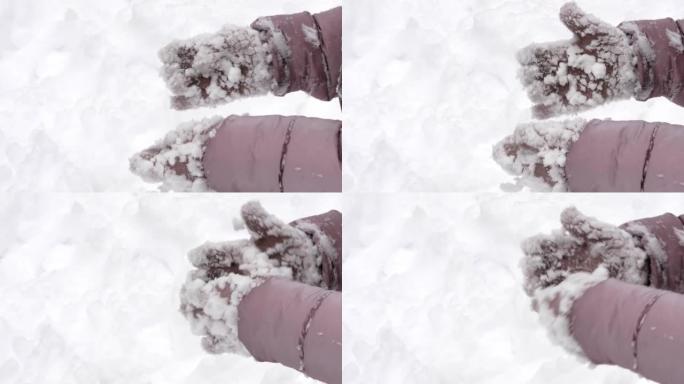 一个孩子在冬天的霜冻编织手套的手被雪块覆盖。手掌紧握不紧握