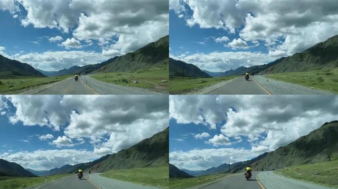 骑自行车的人骑摩托车在风景如画的山蛇形上。