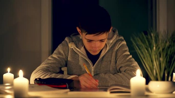 基辅，一个男孩在烛光下做作业
