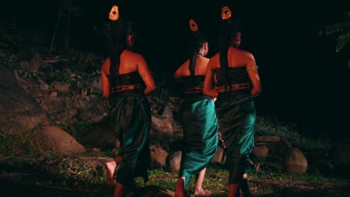 一群亚洲妇女穿着绿色衣服一起走在森林中央