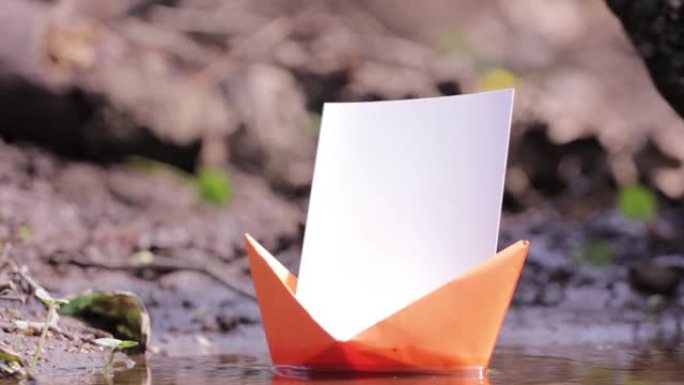 漂浮在岸边高大河附近的橙色纸船