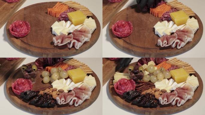 开胃菜板，配有各种奶酪、肉、葡萄和坚果。熟食和奶酪拼盘。速度运动