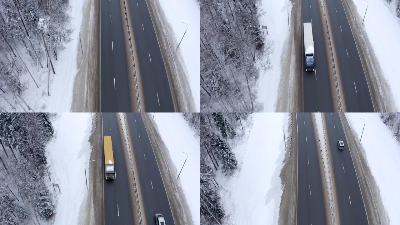 两辆卡车和一辆银色货车的屋顶沿着一条道路行驶，路边积雪和树木。