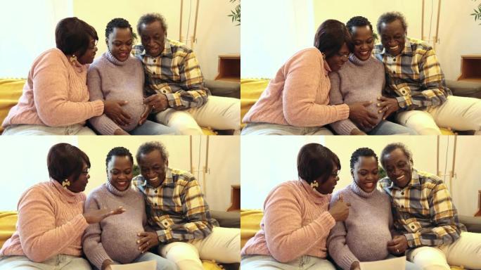 退休的父母和他们怀孕的女儿在家里的沙发上给他们看婴儿的超声波。为他们的新孙子感到高兴