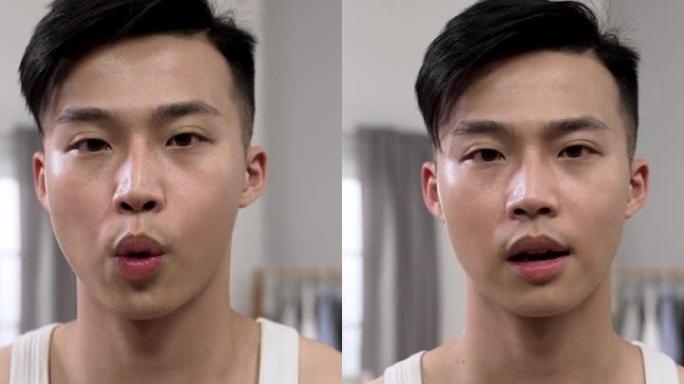 垂直视频:亚洲男性的正面镜头，早上在家里拍着胸脯，像镜子一样看着相机，给自己打气。