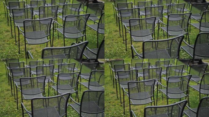 在公园举行的婚礼上，黑色空椅子的后视图，特写镜头，背景上的绿色草坪，慢动作。