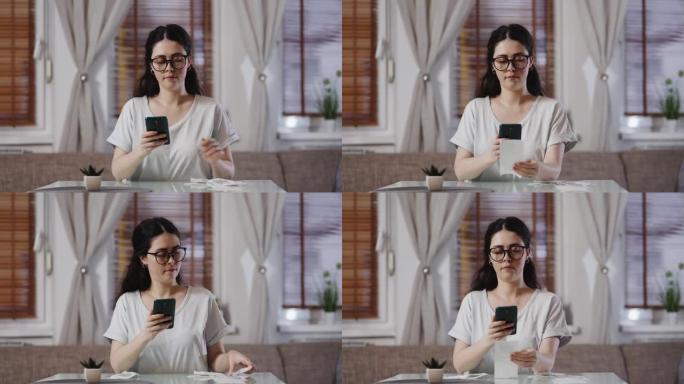 戴着眼镜的年轻漂亮白人妇女用智能手机扫描商店纸质收据上的QR码。会计与退税的概念