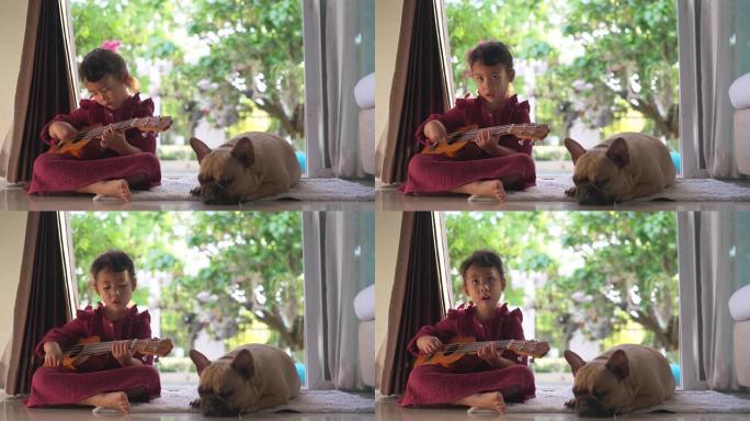 女儿童坐在狗附近的地面上，唱歌和弹吉他