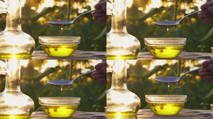 勺子舀起植物油，油从勺子里流出来。玻璃瓶中的植物油