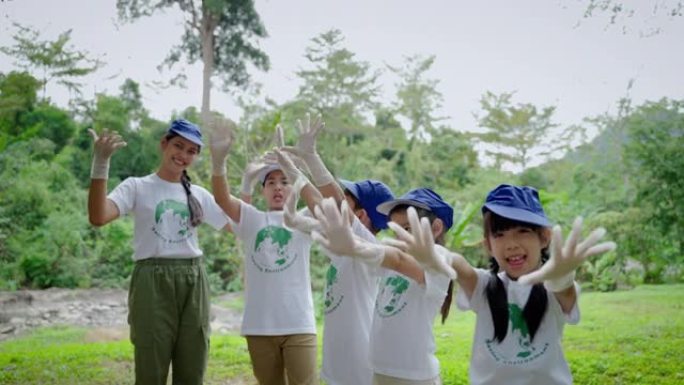 儿童志愿参加社区活动。在开始户外志愿者活动之前，他们戴着手套联手。概念成功团队