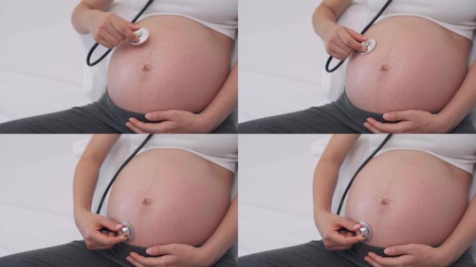 孕妇正在使用听诊器听到婴儿的声音。听未出生的孩子发现未出生的孩子可能异常的声音。孕妇幸福的概念。