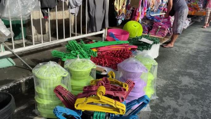 在城镇节日期间，路边的边缘小贩将塑料洗衣物放在路边，并在街上出售。
