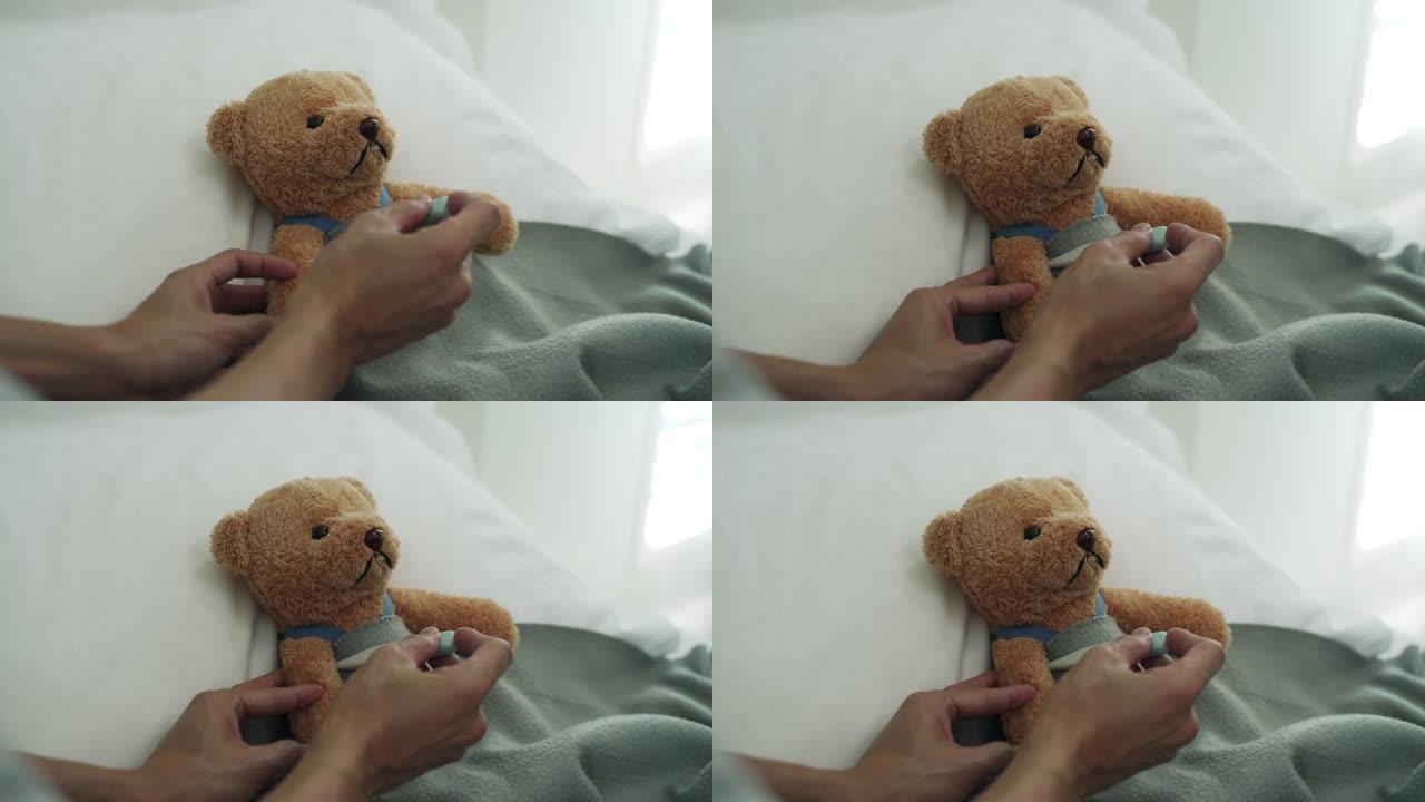 使用熊作为儿童代表的概念。男子用数字温度计测量体温，发现发高烧。