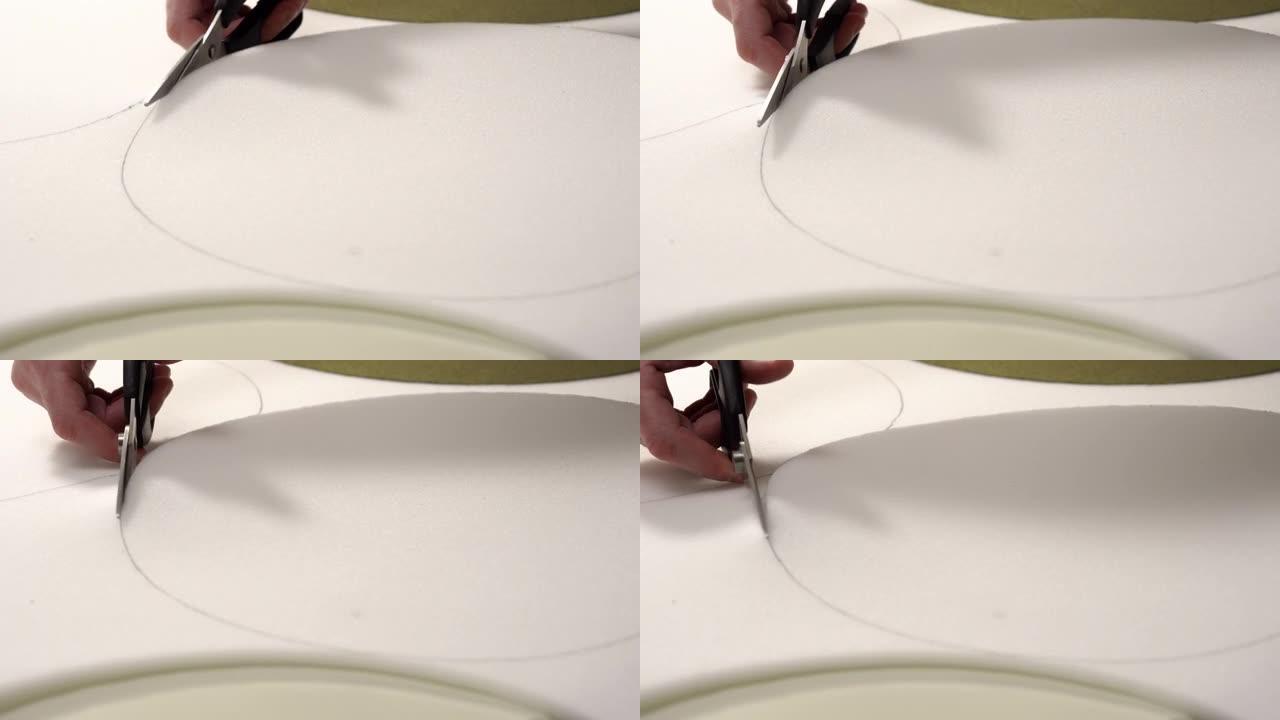 家具修复。一名男子从泡沫橡胶中切出细节，用于装饰家具。特写手