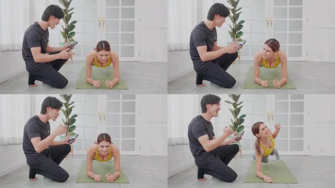 年轻女子练习带姿势板的锻炼，而亚洲男子则指导决心在家中进行挑战，锻炼和训练，并为健康，运动理念而付出