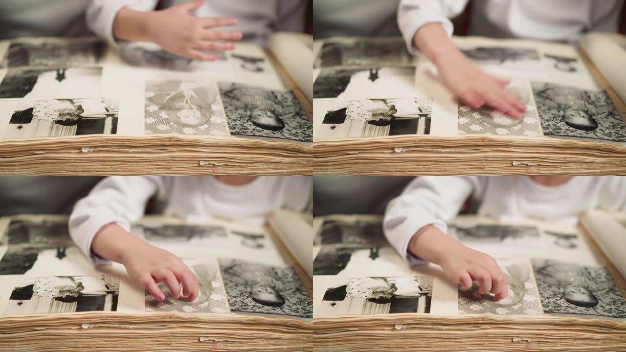 女孩擦拭旧家庭相册中祖母的苍白照片