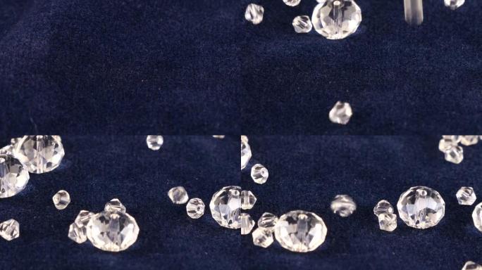 透明的白色珠宝水晶和水钻落在蓝色天鹅绒上。